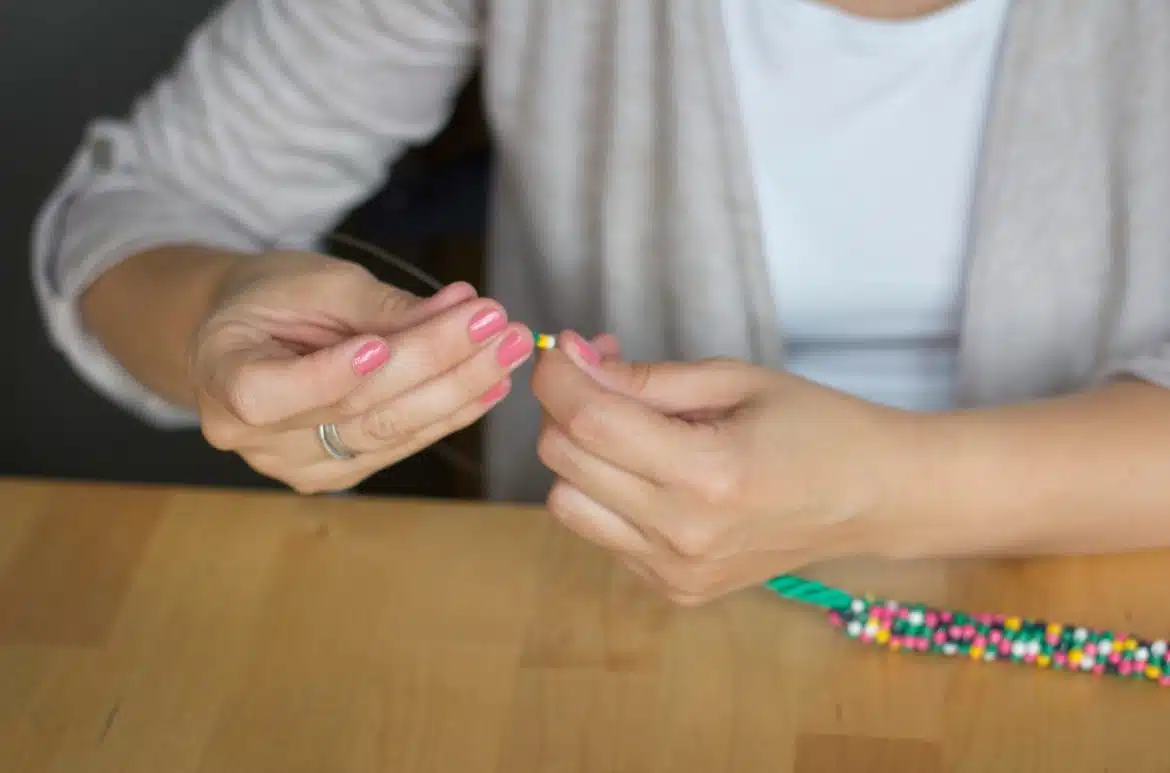 Une jeune femme fabriquant un collier