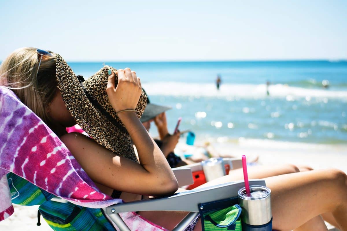 Une femme avec son chapeau à la plage